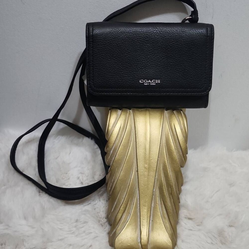 Coach Avery leather phone crossbody w/ a flap closure.